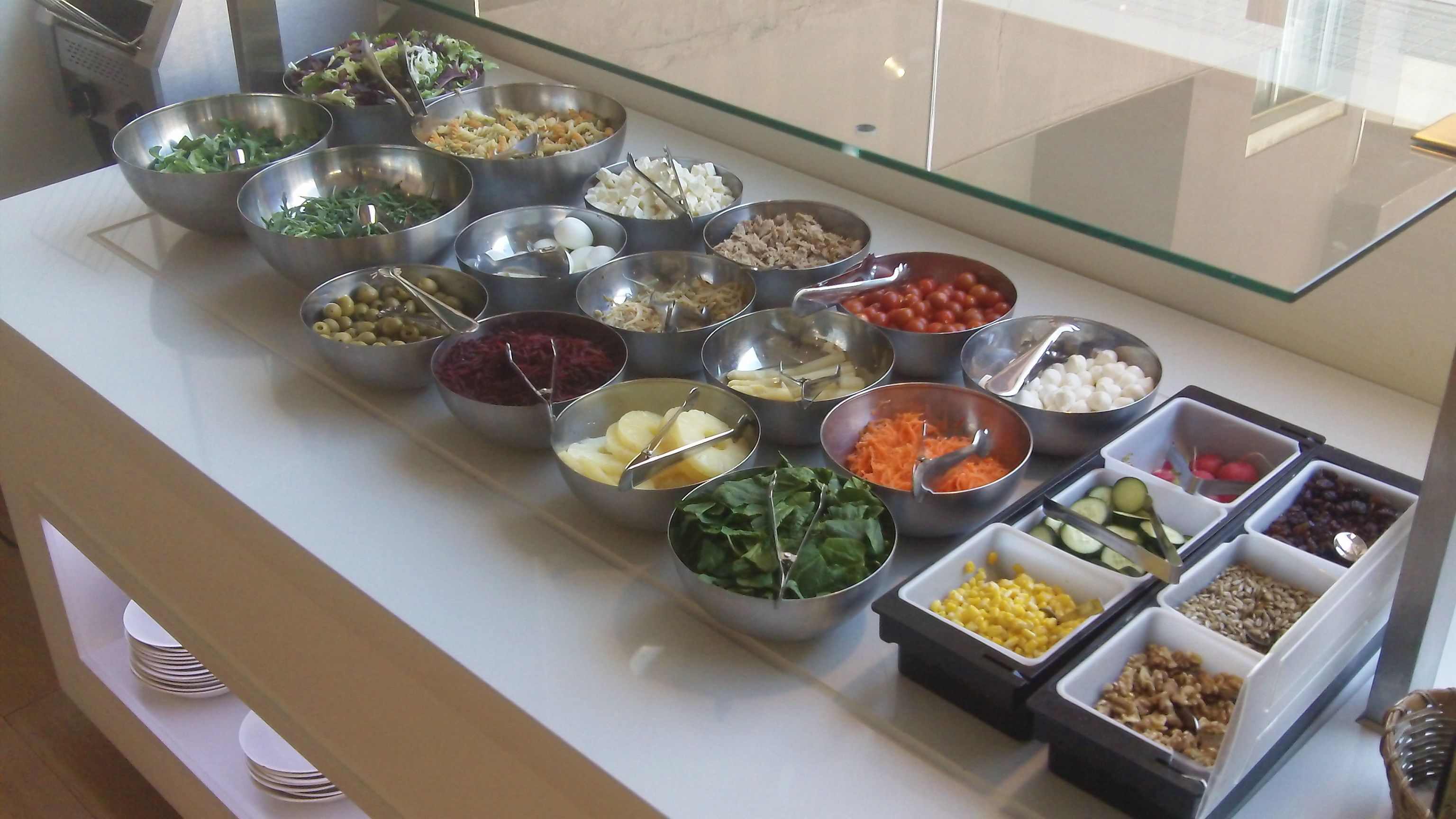Ein Buffet mit verschiedenen Speisen in Metall- und Kunststoffbehältern.