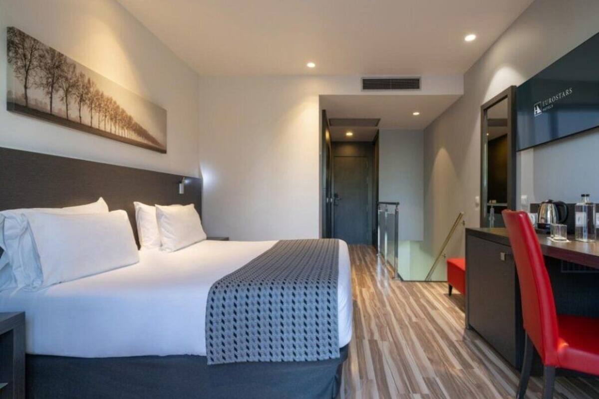 Een moderne hotelkamer met een groot bed, een bureau en een zithoek.