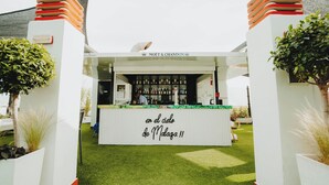 A bar named "MOET & CHANDON" with a sign reading "en el cielo de Malaga!!" and a variety of bottles on display.