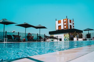 Una piscina al aire libre, sillones reclinables de piscina