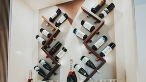 A wine rack with bottles and glasses, a fish display with decorative items, and a digital thermometer.