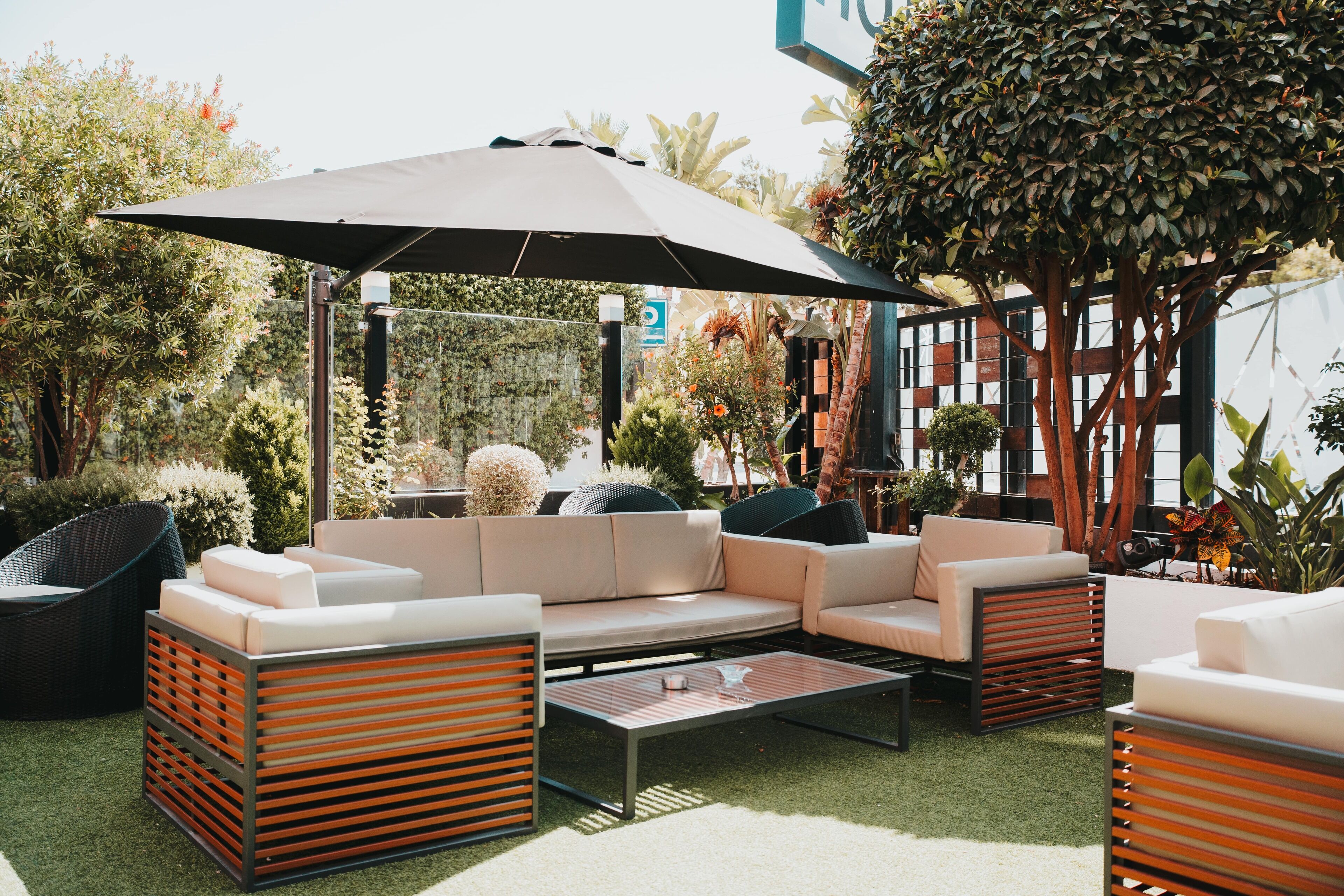 An outdoor patio area with a sofa set, a coffee table, and a large umbrella.