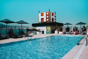 Una piscina al aire libre, sillones reclinables de piscina