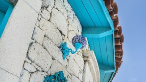 A turquoise-framed mirror on a stone wall, a white television, and a blue roof. - Alacati Degirmen Otel (Cesme)