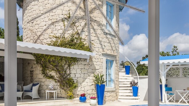 A stone building with a blue roof, a pool with blue tiles, and a white pergola. - Alacati Degirmen Otel (Cesme)