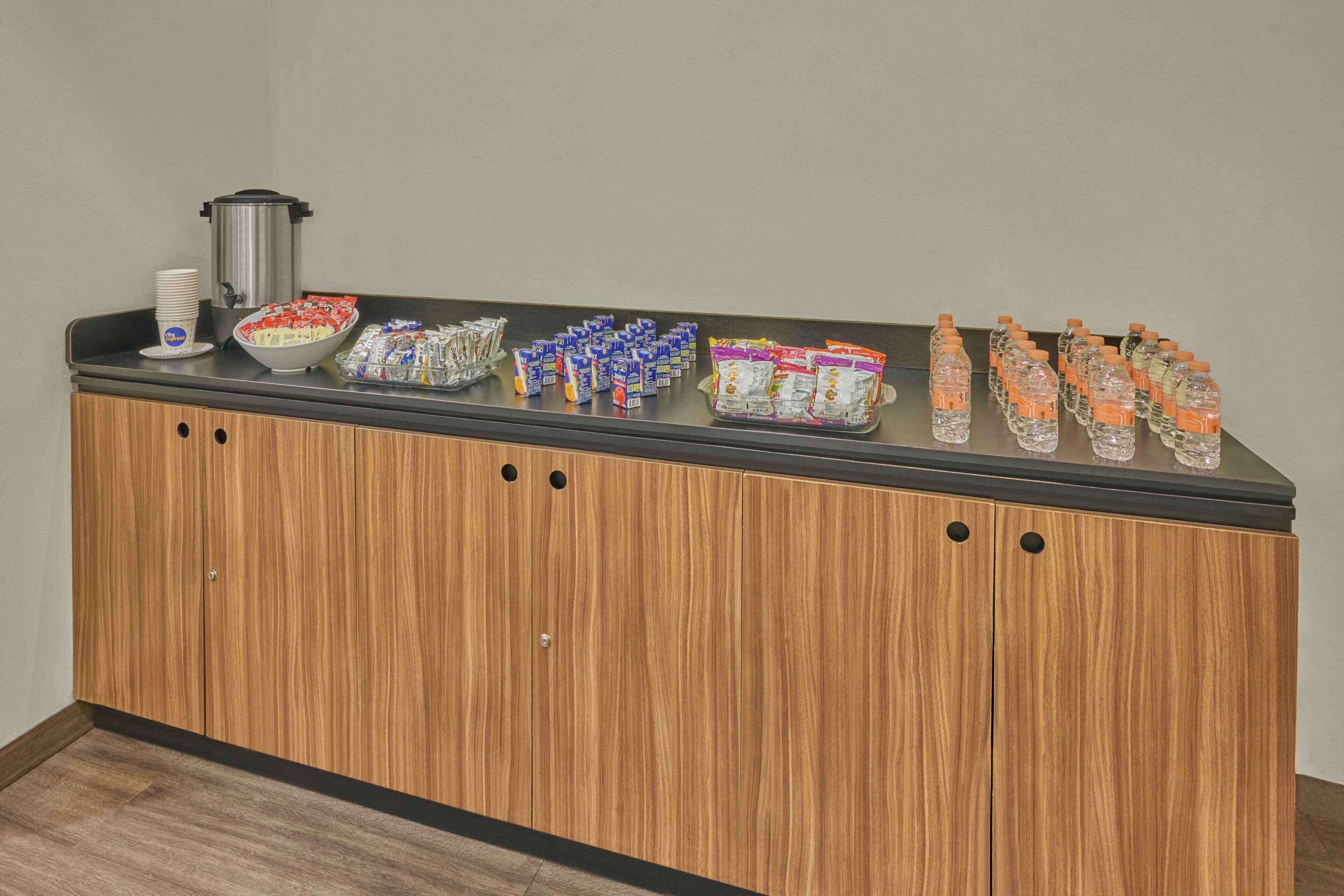 Un mostrador con una variedad de alimentos y bebidas para un servicio tipo buffet.
