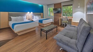 A hotel room with two beds, a desk, a grey sofa, and a TV. - City Express by Marriott Playa Del Carmen (Playa del Carmen)