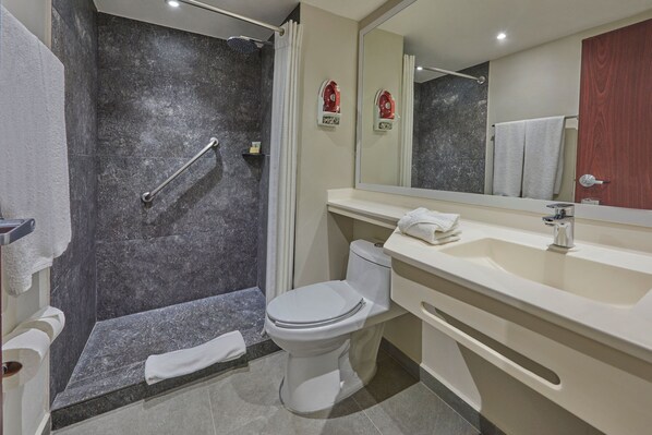 Un baño moderno con ducha, inodoro y lavamanos.