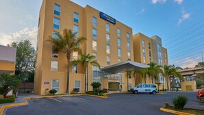 A CityExpress Hotel building with a flat facade, multiple windows, and a covered entrance. - City Express by Marriott Puebla Finsa (Cuautlancingo)