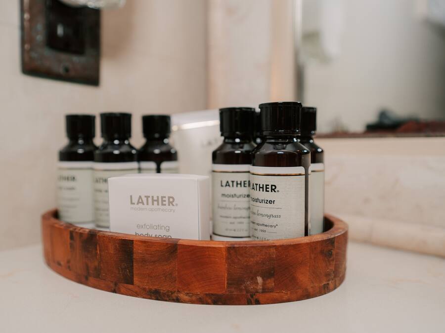 Una bandeja de madera con diversos productos de cuidado corporal Lather.