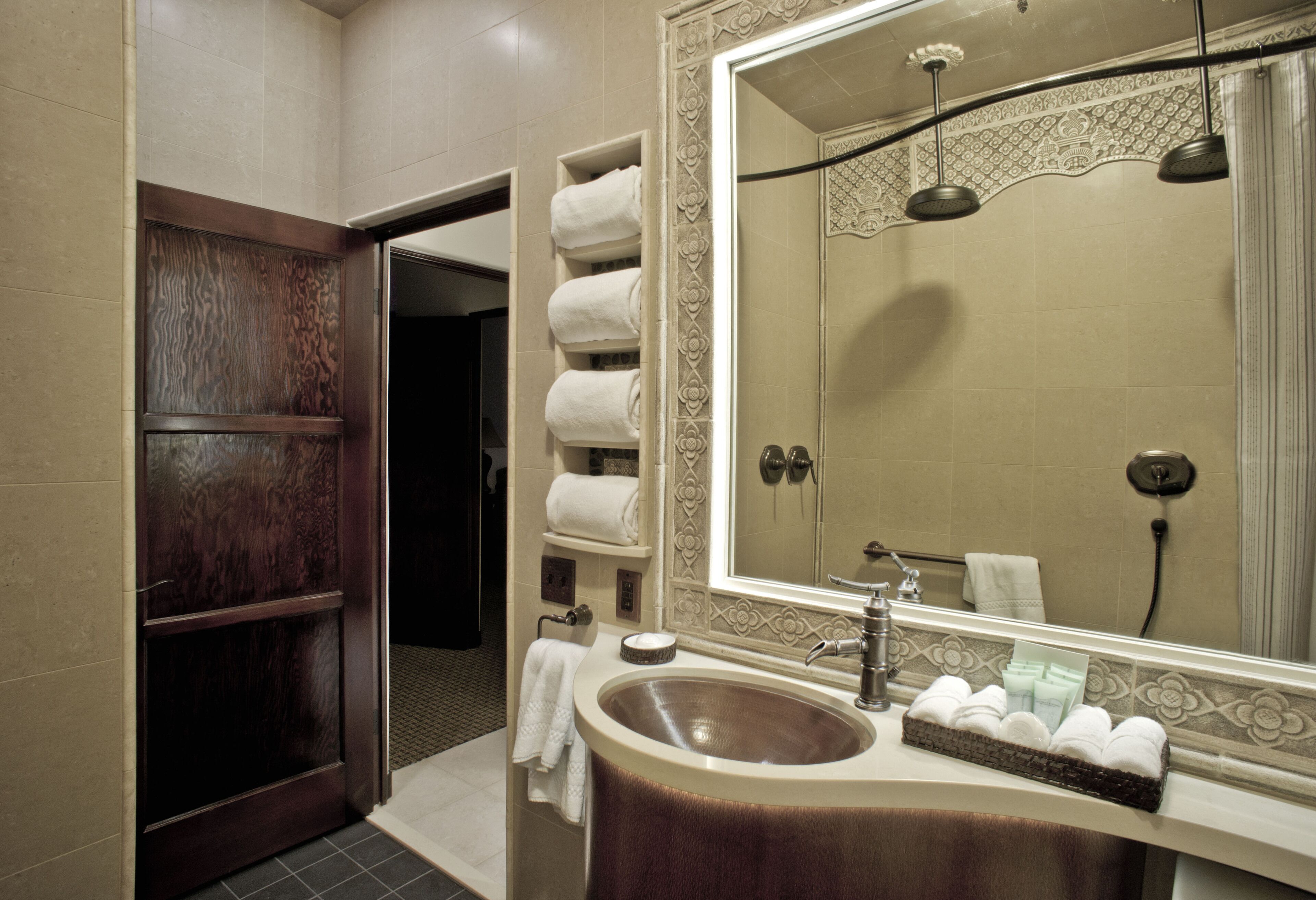 Un baño con un espejo grande, un lavamanos y una ducha.