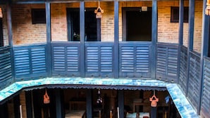 Un bâtiment traditionnel doté d’un balcon, de meubles en bois et de décorations suspendues.