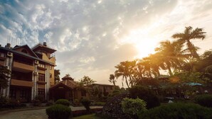 A hotel with a traditional architectural style, featuring a prominent tower and multiple balconies. - Safari Adventure Lodge (Sauraha)