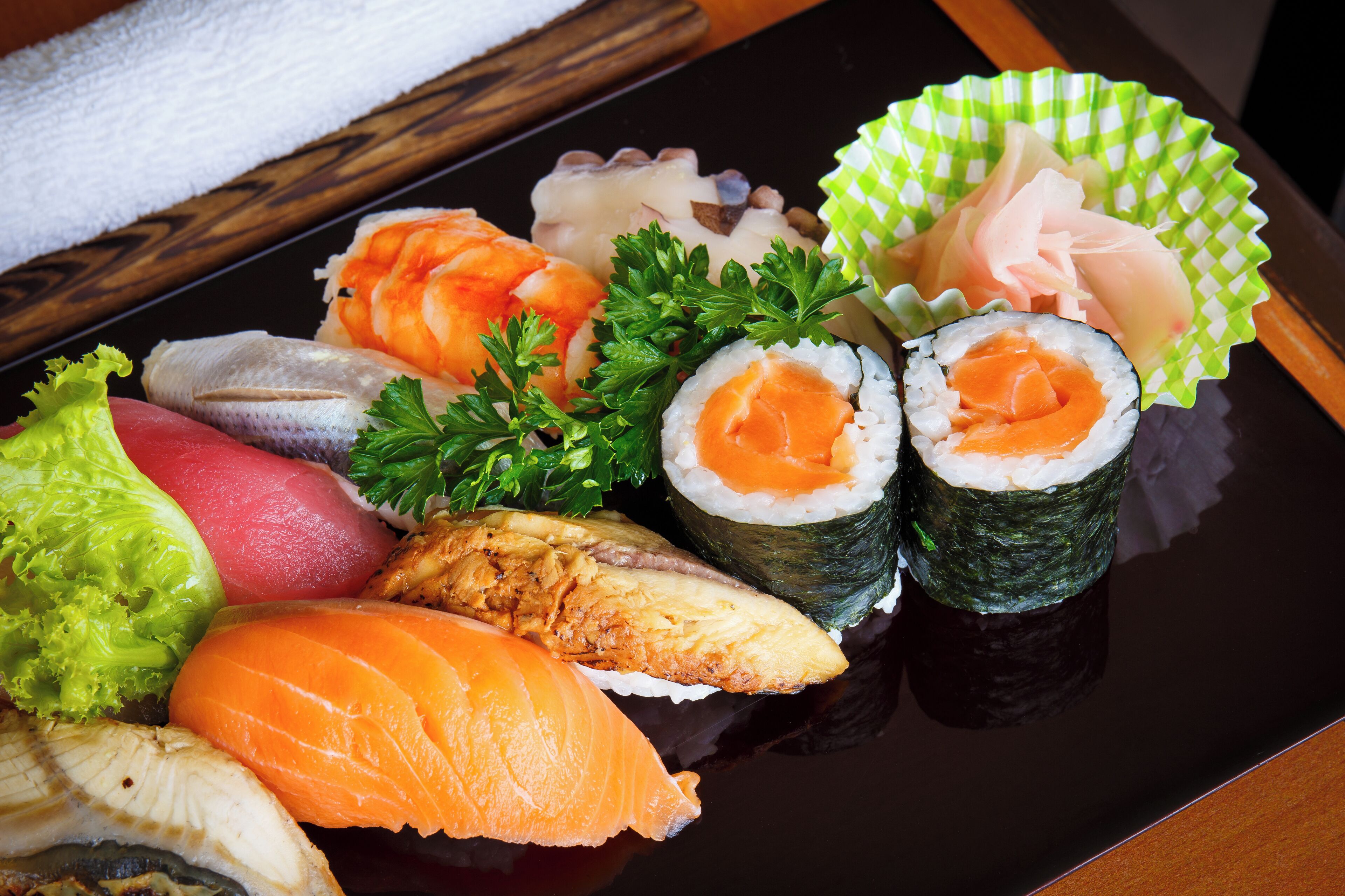 Variedad de sushi sobre un plato negro.