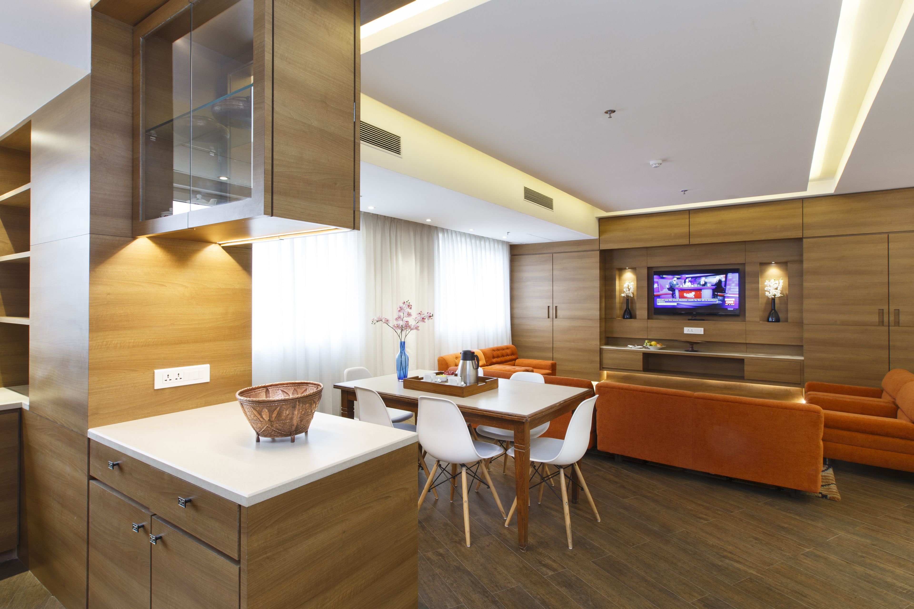 Une chambre d’hôtel moderne dotée d’un coin repas, d’un canapé et d’une télévision.