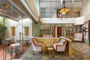 A lobby with a reception desk, seating area, and decorative elements.