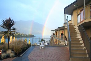 A building with a staircase, a view of a lake, and a rainbow. - Alexis Motels & Apartments (Queenstown)
