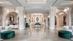 A spacious lobby with a central reception desk, seating areas, and a modern ceiling design. - Notre Dame of Jerusalem Center (Jerusalem)