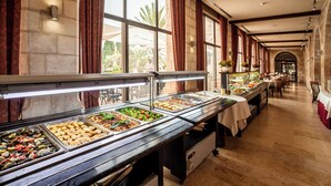A buffet with various food options, a long counter, and a view of the outdoors through large windows. - Notre Dame of Jerusalem Center (Jerusalem)