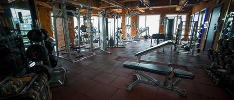 A gym with various exercise equipment, including weight machines and dumbbells.