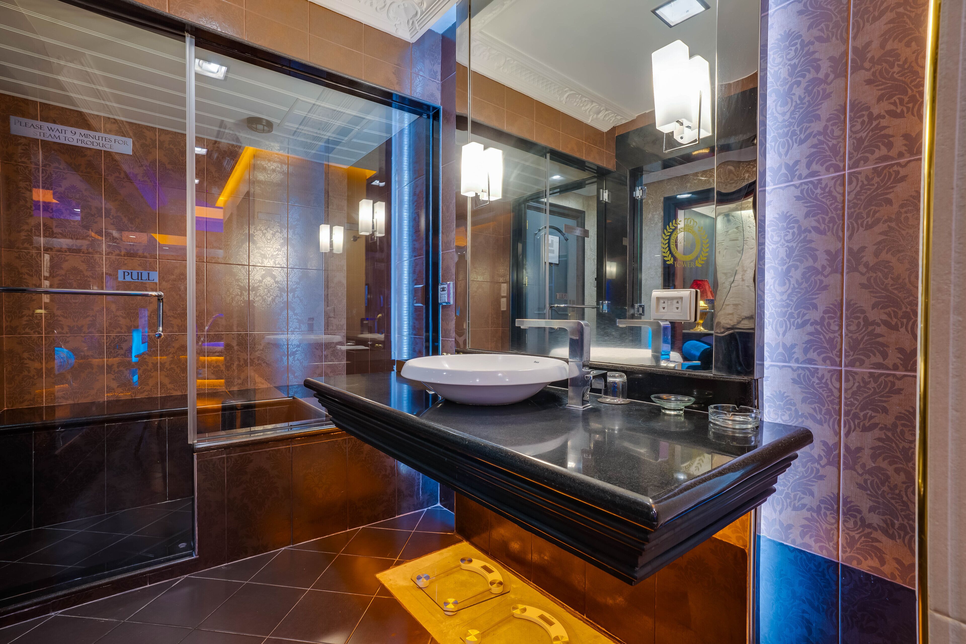 Un baño moderno con un espejo grande, un lavabo y una cabina de ducha de vidrio.