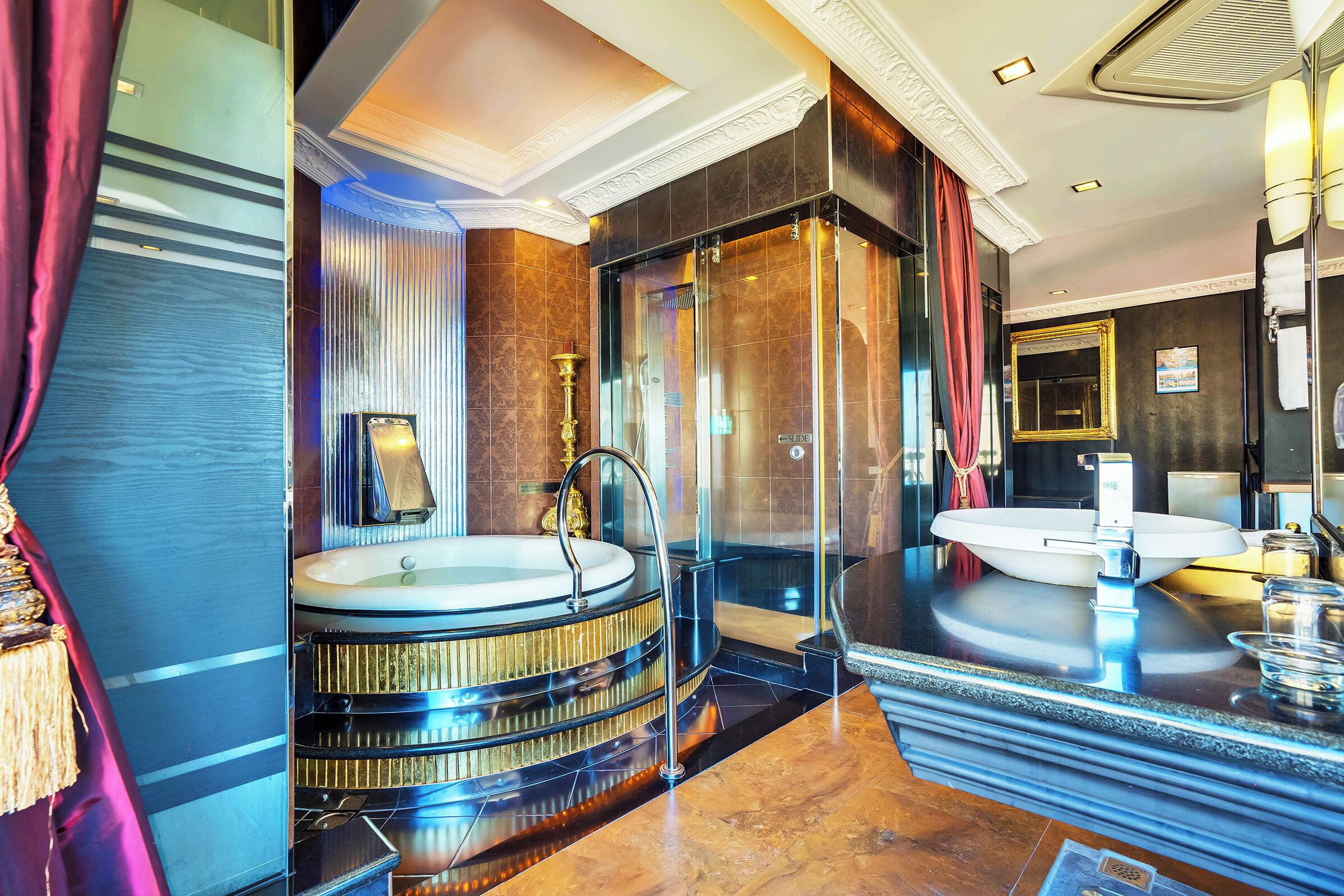 A luxurious bathroom with a large bathtub, a separate shower area, and a vanity with a mirror.