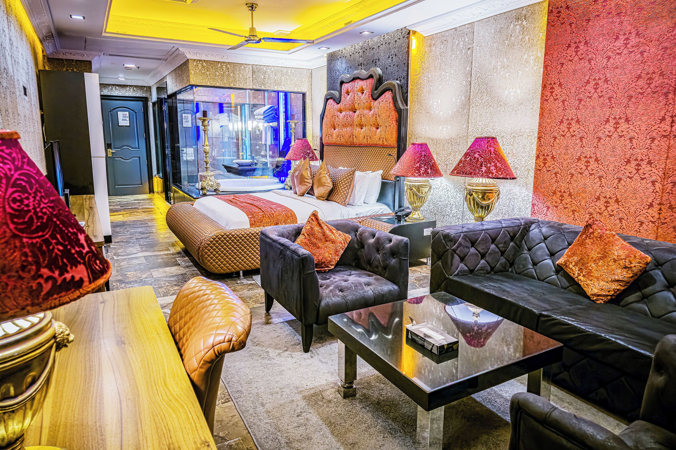 Una lujosa habitación de hotel con una cama grande, varias zonas de estar y un diseño moderno.