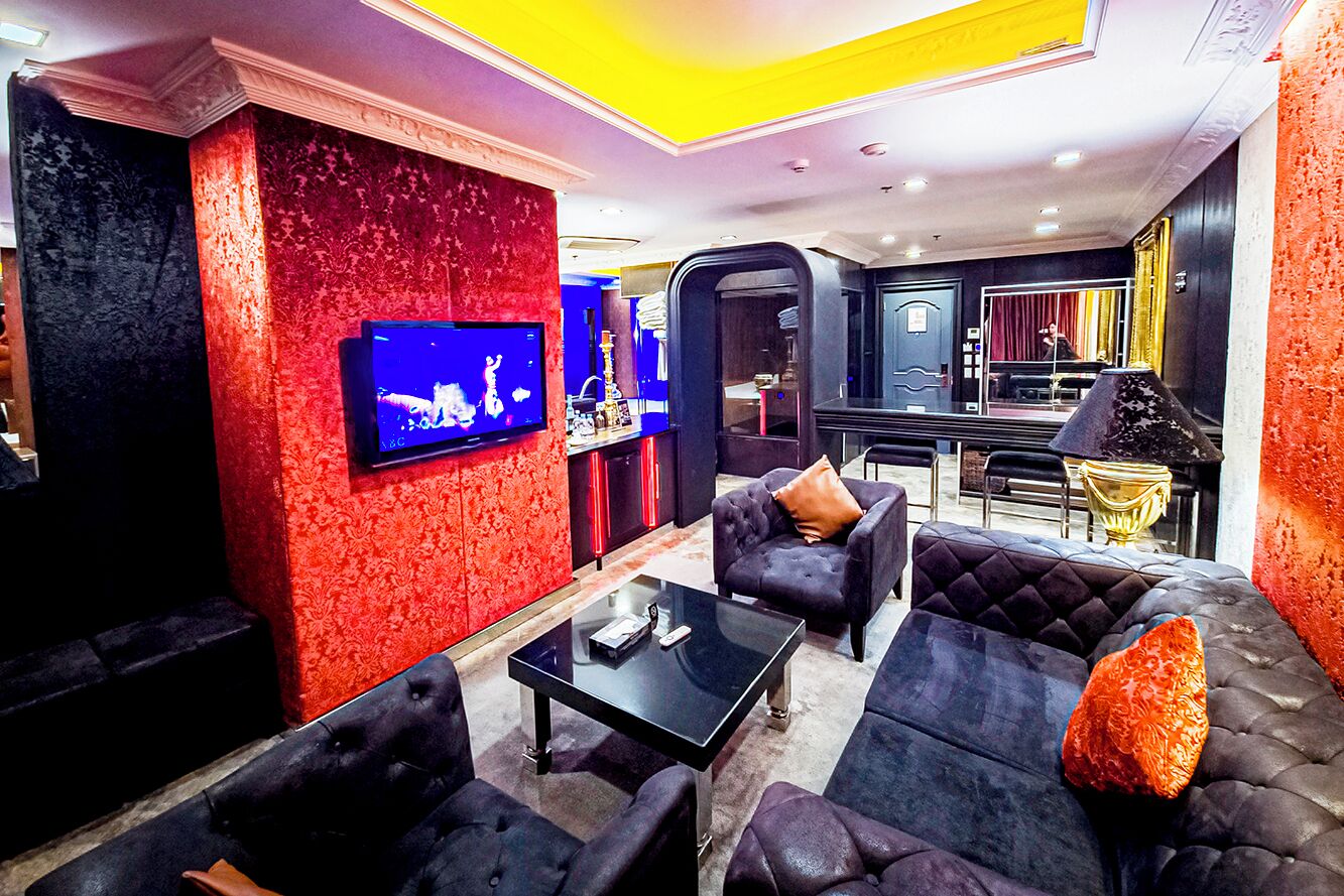 A modern lounge area with a television, sofas, and a coffee table.