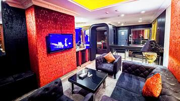A modern lounge area with a television, sofas, and a coffee table.