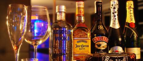 Una barra con varias botellas de licor y dos vasos vacíos.