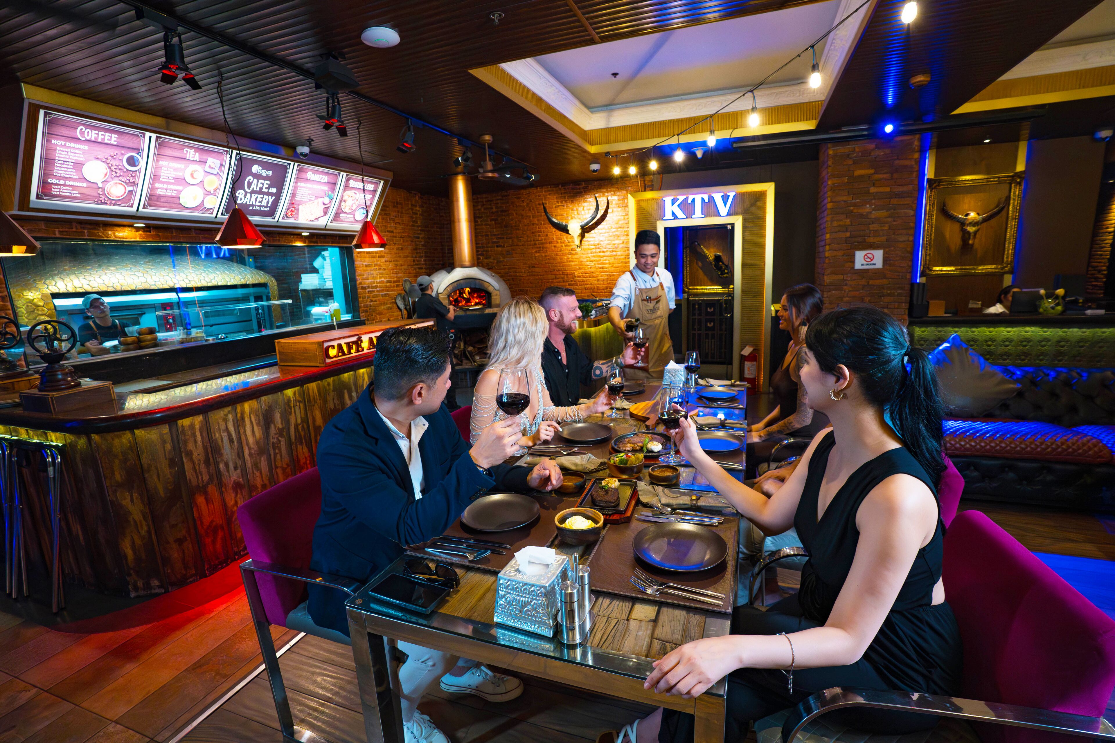 A restaurant with a brick wall, a counter with a menu, and a TV screen displaying the menu.