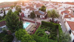 A courtyard with a swimming pool, surrounded by white buildings with red-tiled roofs. - Casa do Terreiro do Poço (Borba)