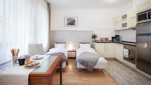 Ett modernt hotellrum med en säng, ett nattduksbord och ett litet pentry.