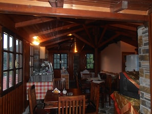 Un coin repas rustique, avec des meubles en bois, une nappe à carreaux et un mur en pierre.
