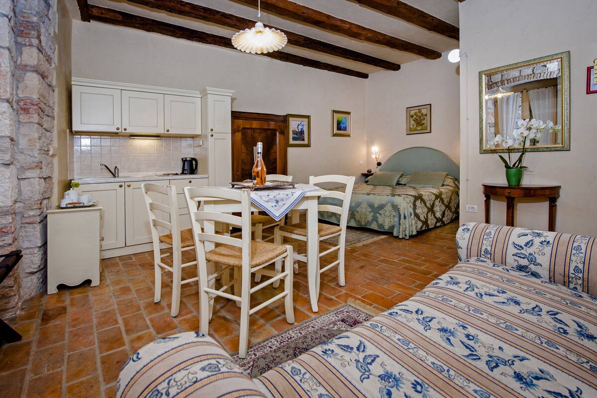 Un espacio habitable compacto con cocina, comedor y cama.