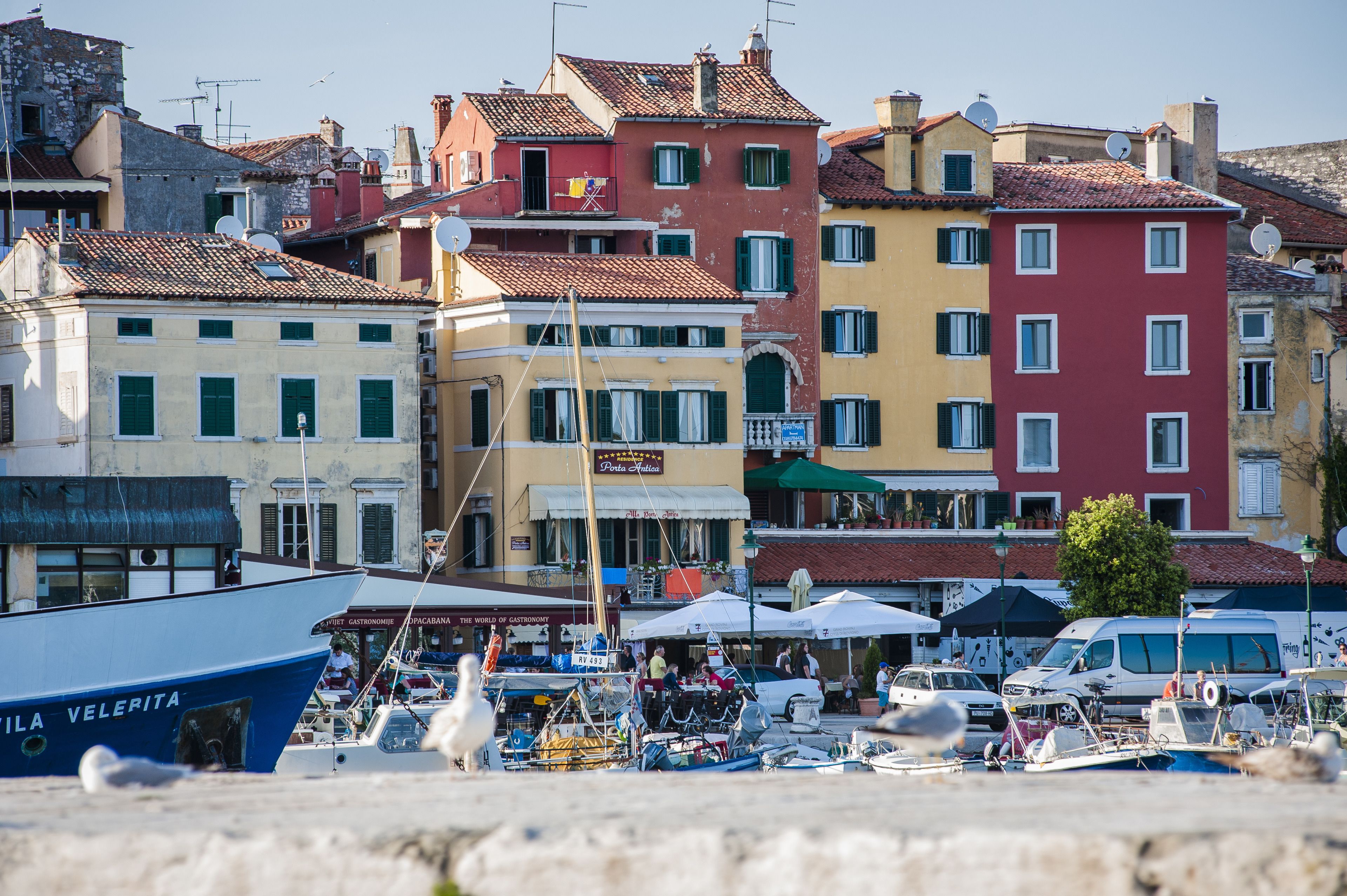 A marina with colorful buildings, boats, and a clear sky.