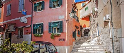 A red and pink building with a golf cart parked in front.
