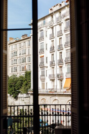 A multi-story building with balconies, a stone wall, and a clear sky. - Simple Stay - Fresh Start May 2026 (Nice)