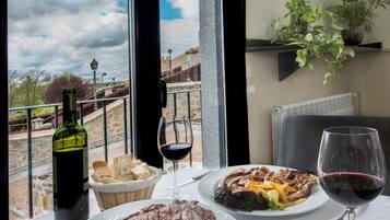 Una mesa de comedor con platos de comida, copas de vino y una botella.