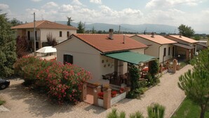 A residential area with houses featuring tiled roofs and a gravel driveway. - Terra dei Santi Country House (Spello)