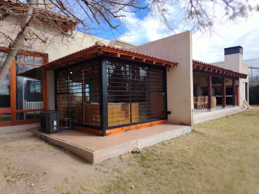 A modern building with a covered patio area, large windows, and a visible outdoor seating area.