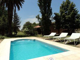 Una piscina al aire libre, tumbonas
