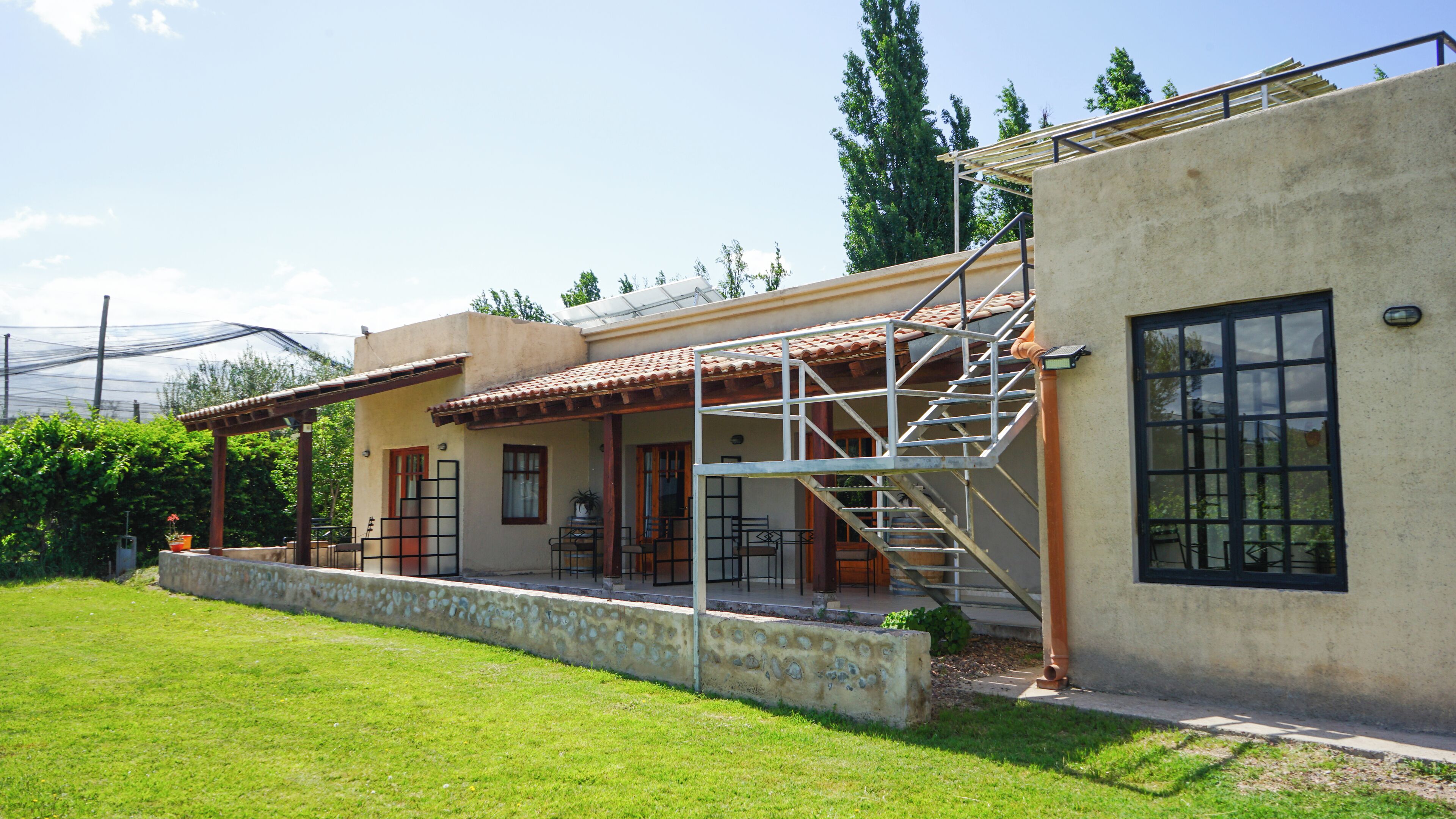 A two-story house with a patio, a staircase, and a large window.