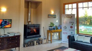 Una sala de estar con chimenea, un sofá, una mesa de centro y un televisor.