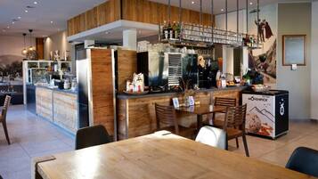 Ein Restaurant-Interieur mit einer Holztresore, Sitzgelegenheiten und einem Wandgemälde.