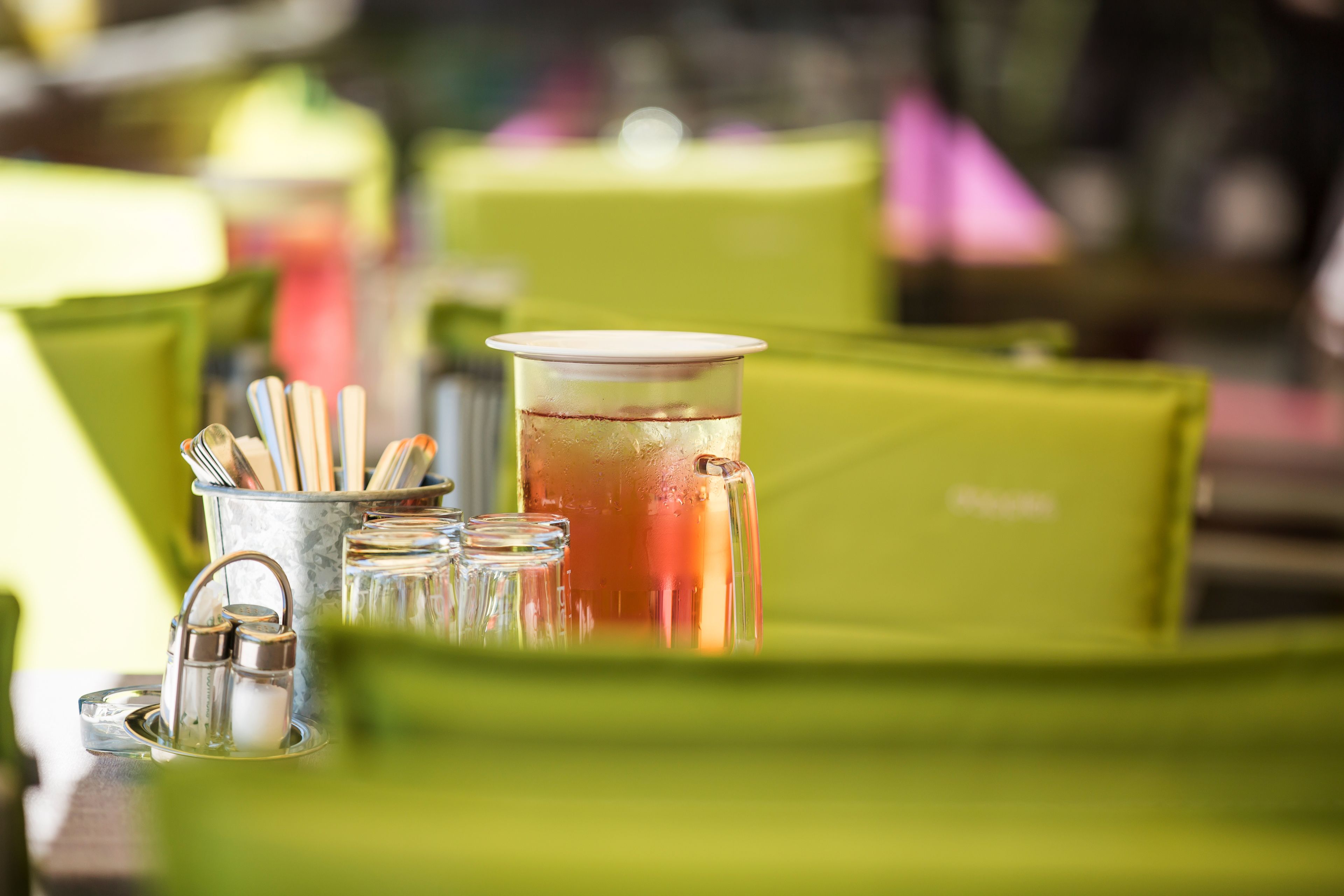 A table with a glass pitcher, salt and pepper shakers, and a metal cup holder.