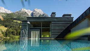 Un bâtiment moderne doté d’une piscine, d’un escalier et offrant une vue sur la montagne.