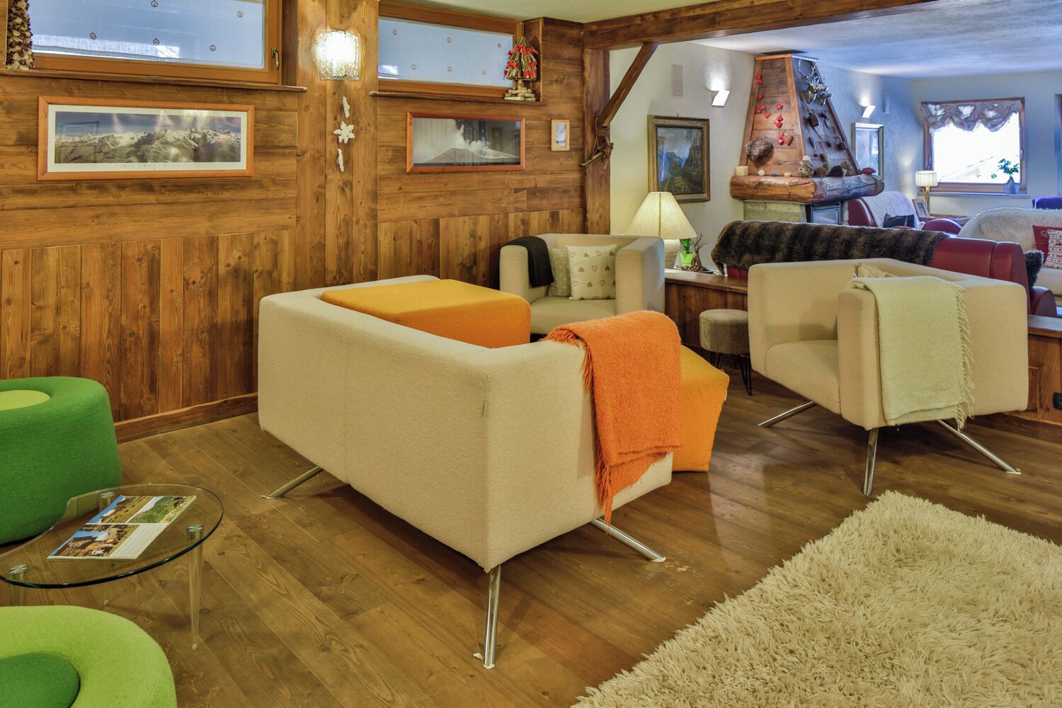 Una sala de estar acogedora con paredes de madera, una chimenea y un sillón verde.