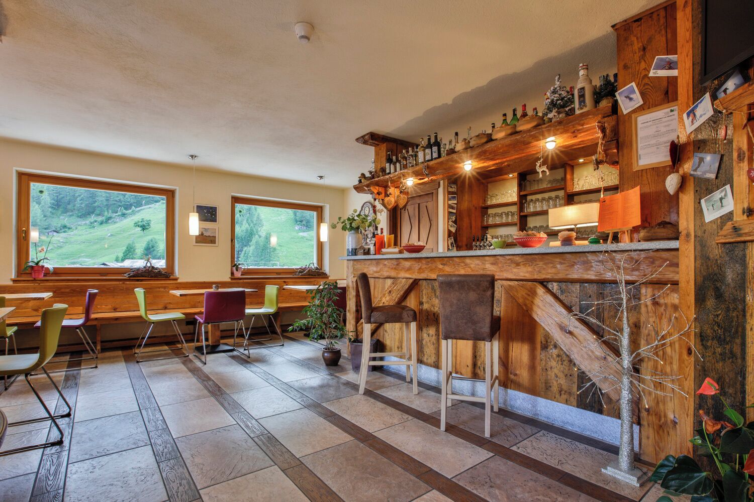 Un rincón acogedor de bar con estantes de madera, asientos y vistas al exterior.