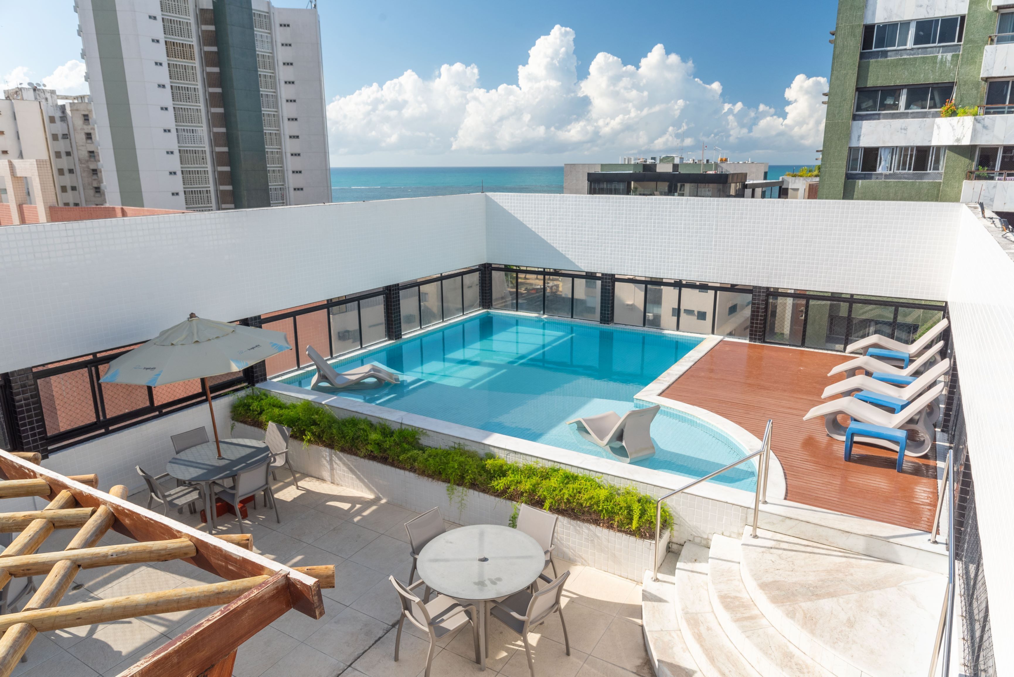 Alberca al aire libre, sombrillas en la alberca y camastros 